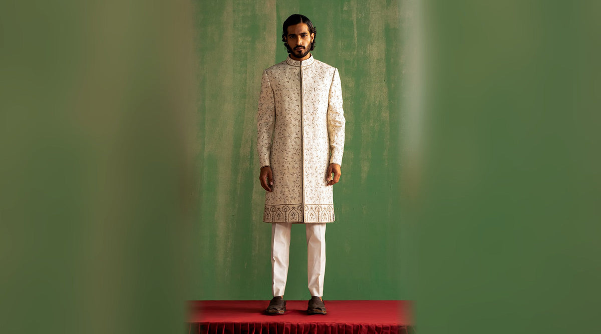 Ivory sherwani with tonal floral hand embroidery and arch-motif hem border, full length — Studio Bagechaa