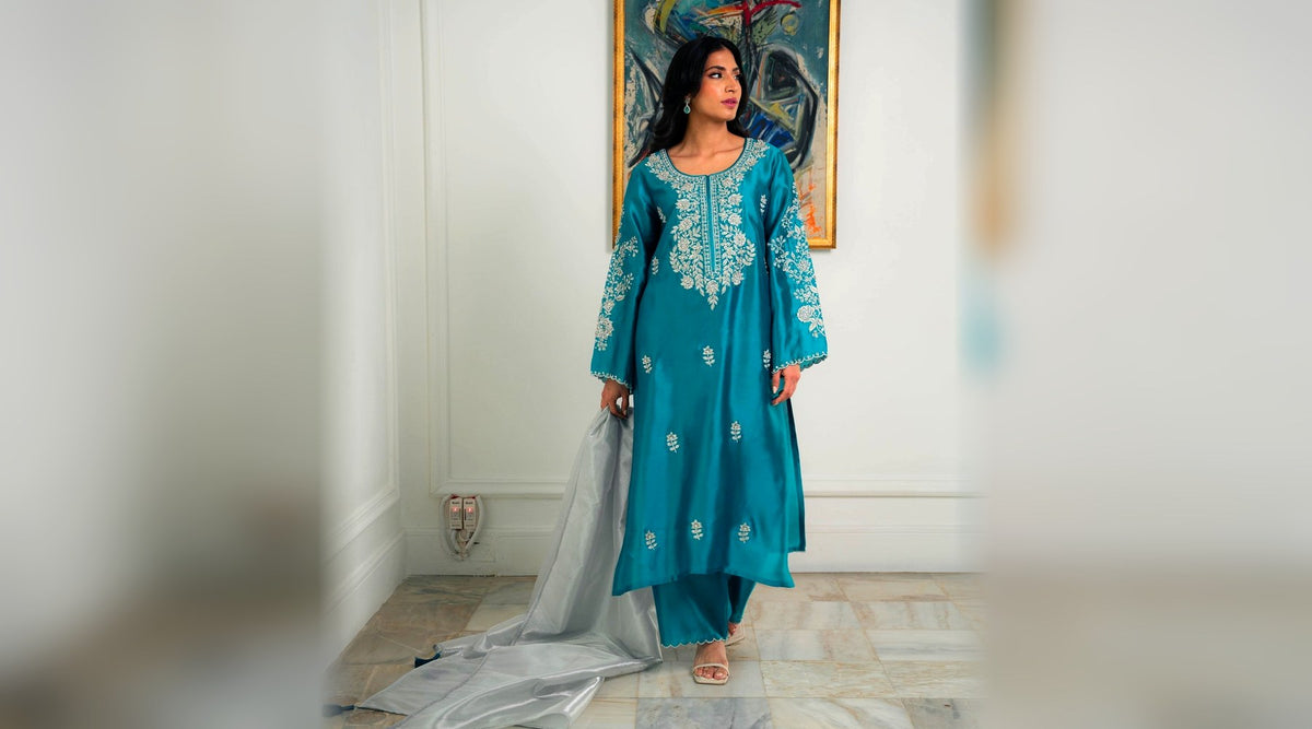 Teal silk kurta with silver zari embroidered neckline and sleeve vines, worn with organza dupatta — Khushboo & Pankaj
