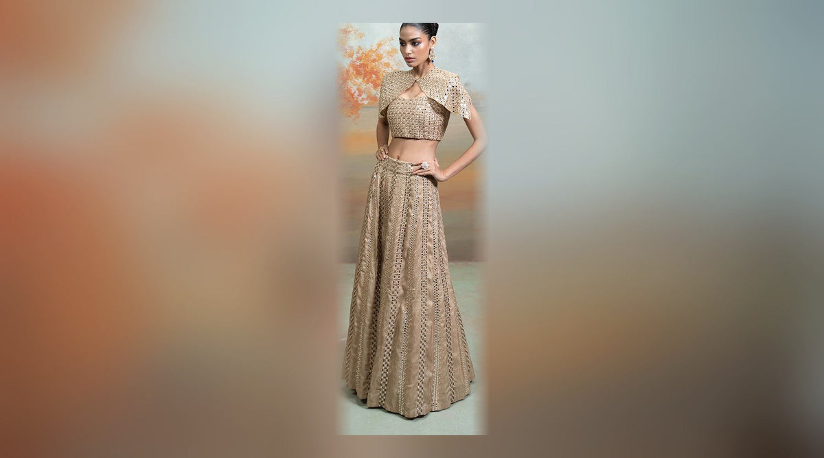 Golden zardozi mirror cutdana raw silk lehenga set for dhanteras 2026 outfits — gold mirror-work lehenga with embellished blouse and sheer cape, full outfit on a model